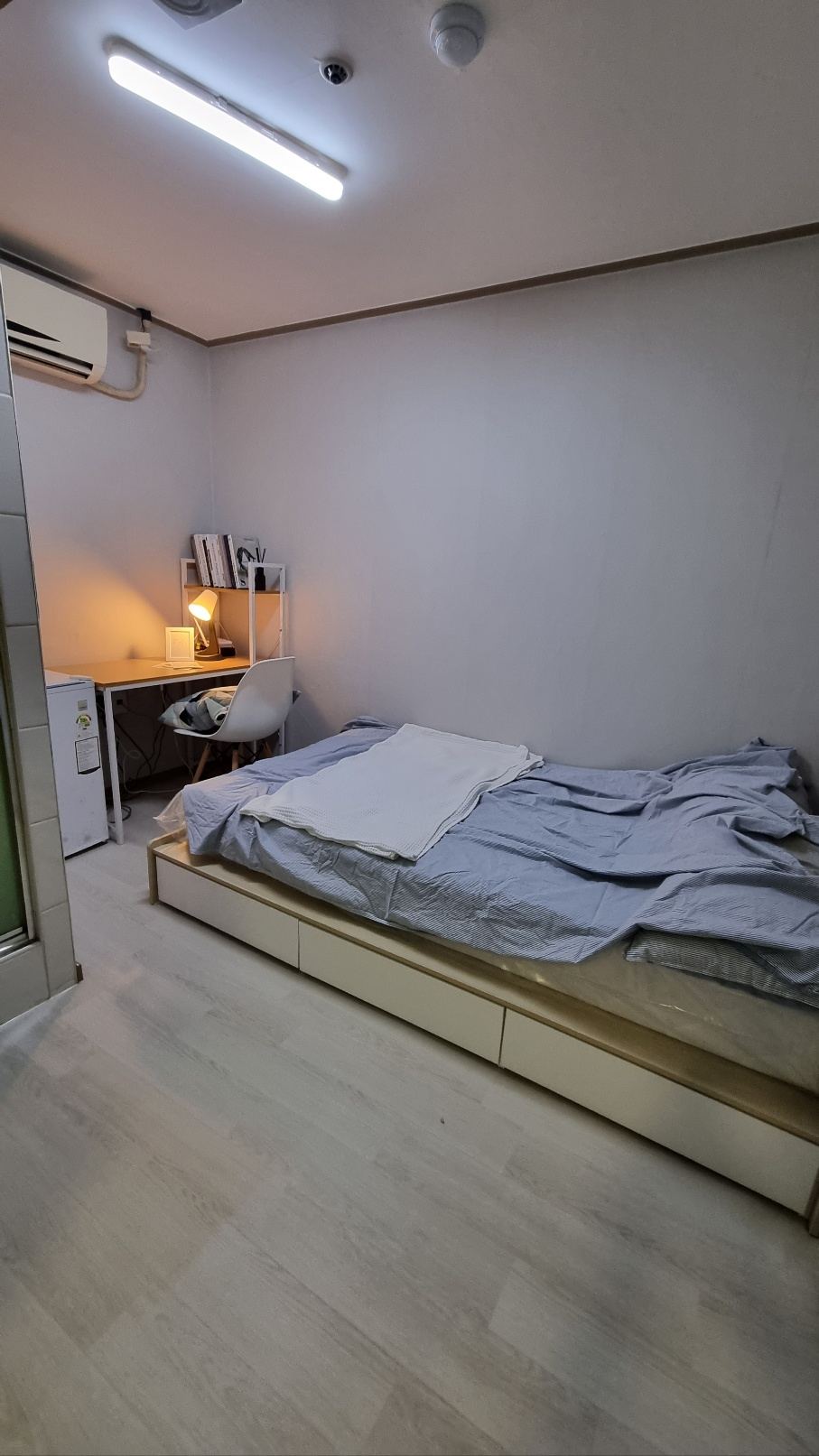 천안 고시원 규스테이 에어컨 아래 침대와 책상